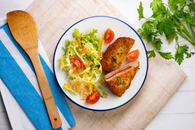 Asturian Cachopo. Breaded beef fillet stuffed with cheese and pepper. Top view table with decoration. clipart