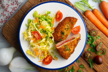 Asturian Cachopo 'su. Peynir ve biberle doldurulmuş dana fileto. Dekorasyonlu üst görünüm tablosu.