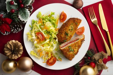 Asturian Cachopo. Breaded beef fillet stuffed with cheese and pepper. Top view table with Christmas decoration. clipart