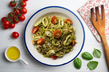 Pesto soslu İtalyan eriştesi ve kalamar. Dekorasyonlu üst görünüm tablosu.