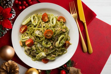 Pesto soslu İtalyan eriştesi ve kalamar. Noel süslemeli üst manzara masası.