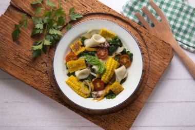 Mürekkep balıklı Akdeniz mısır salatası. Dekorasyonlu üst görünüm tablosu.