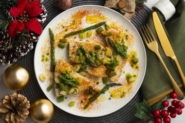 Yeşil kuşkonmazlı ızgara kılıçbalığı. Noel süslemeleri ile en üstteki görünüm masası.