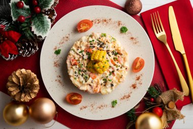 Patates, mısır ve mayonezli Rus salatası. Noel süslemeli üst manzara masası.