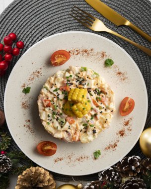 Patates, mısır ve mayonezli Rus salatası. Noel süslemeli üst manzara masası.