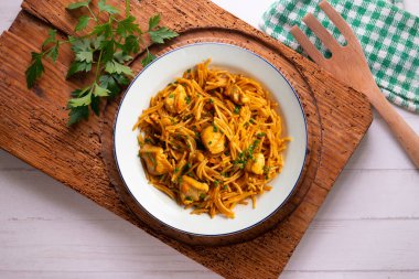 İspanyol paellası, fideua, sebze ve tavuk. Dekorasyonlu üst görünüm tablosu.