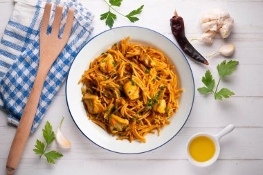 İspanyol paellası, fideua, sebze ve tavuk. Dekorasyonlu üst görünüm tablosu.