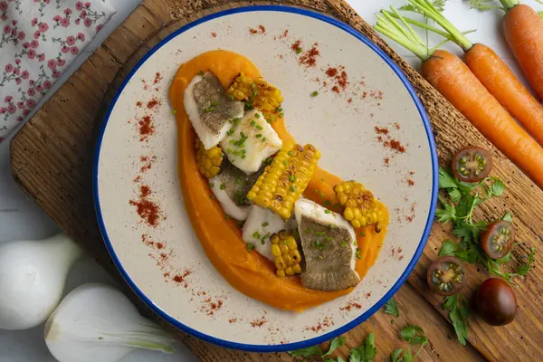 stock image Delicious sole fish with carrot cream and corn. Top view table with Christmas decorations.