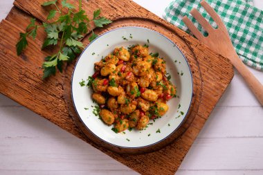 Pesto rosso soslu İtalyan gnocchi 'si. Dekorasyonlu üst görünüm tablosu.