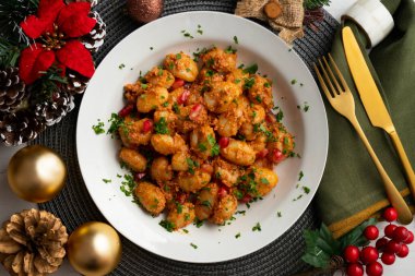 Pesto rosso soslu İtalyan gnocchi 'si. Noel süslemeleri ile en üstteki görünüm masası.