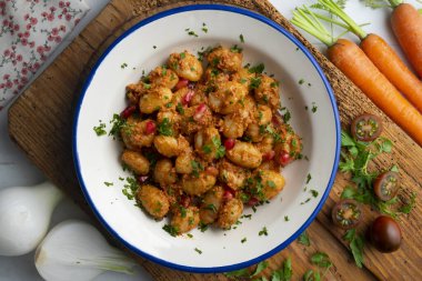 Pesto rosso soslu İtalyan gnocchi 'si. Dekorasyonlu üst görünüm tablosu.
