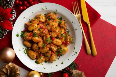 Pesto rosso soslu İtalyan gnocchi 'si. Noel süslemeleri ile en üstteki görünüm masası.