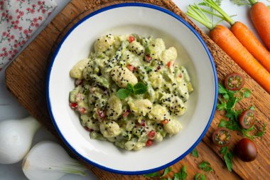 Yoğurt soslu lezzetli gnocchi ve yeşil kuşkonmaz. Dekorasyonlu üst görünüm tablosu.