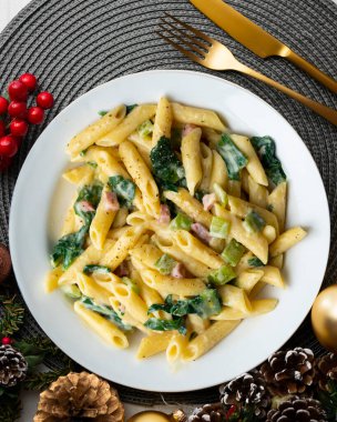 Pazı, jambon ve krema soslu İtalyan makarnası. Noel süslemeleri ile en üstteki görünüm masası.