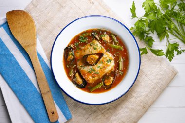 Hake domates ve midye ile pişirilir. Noel süslemeli üst manzara masası.