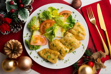 Tempura hake parçaları ve salata. Noel süslemeli üst manzara masası.