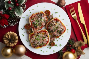 Ham and mini pizzas with mushrooms. Top view table with Christmas decoration. clipart