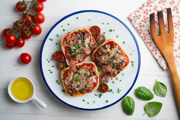 Jambon ve mantarlı mini pizzalar. Dekorasyonlu üst görünüm tablosu.