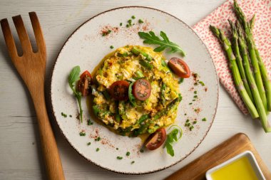 Yeşil kuşkonmaz ve domatesli çırpılmış organik tavuk yumurtası. Dekorasyonlu üst görünüm tablosu.