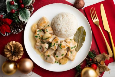 Yaprak aromalı sarımsaklı tavuk ve beyaz pirinç. Noel süslemeli üst manzara masası.