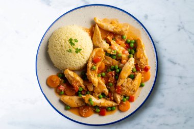 Sebze ve domates soslu sotelenmiş tavuk şeritleri. Dekorasyonlu üst görünüm tablosu.