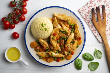 Sebze ve domates soslu sotelenmiş tavuk şeritleri. Dekorasyonlu üst görünüm tablosu.