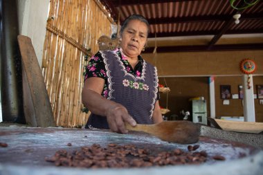 Teotitlan del valle, Oaxaca, Meksika; 1 Kasım 2024: Oaxaca 'da bir kadın odun yakan sobada kakao çekirdeği pişiriyor..