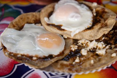 Oaxaca Merkez Abastos Pazarı 'nda yerel peynir, kurutulmuş domuz eti, yumurta ve acı sos ile memelalar pişiriyorum..