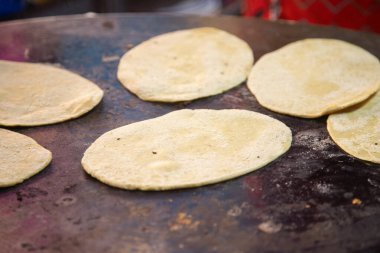 Oaxaca Merkez Abastos Pazarı 'nda yerel peynir, kurutulmuş domuz eti, yumurta ve acı sos ile memelalar pişiriyorum..