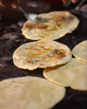 Oaxaca Merkez Abastos Pazarı 'nda yerel peynir, kurutulmuş domuz eti, yumurta ve acı sos ile memelalar pişiriyorum..