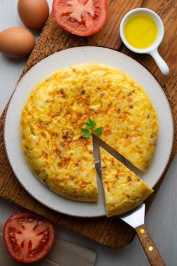 Ahşap bir tabanda geleneksel İspanyol patates omleti manzarası.