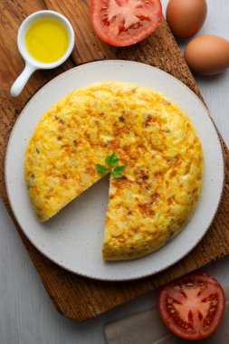 Ahşap bir tabanda geleneksel İspanyol patates omleti manzarası.