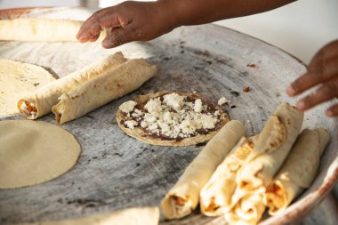Oaxaca 'da bir sokakta tortilla, flautilla ve Meksika memelaları pişiren bir kadın..
