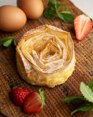 Tuğla hamurdan yapılmış çiçek şeklinde pasta ve yumurta ve şekerli krema..