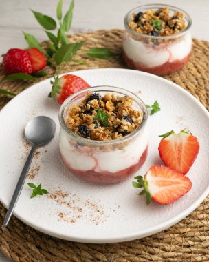 Çilekli Yunan yoğurdu ve tahıl gevreği ve fındıklı granola..