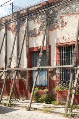 Atlixco, Puebla, Meksika: 1 Kasım 2024: Bir şehir caddesindeki eski güçlendirilmiş ve hasarlı bina duvarı.