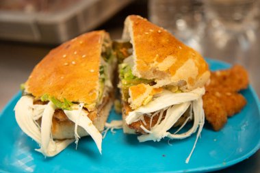 Cemita Poblana. Geleneksel bir Meksika sandviçi. Ekmekli domuz eti, acılı chipotle, quesillo peyniri ve papalo yaprakları..