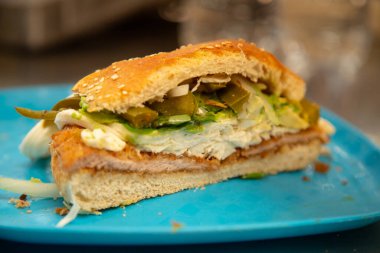 Cemita Poblana. Geleneksel bir Meksika sandviçi. Ekmekli domuz eti, acılı chipotle, quesillo peyniri ve papalo yaprakları..