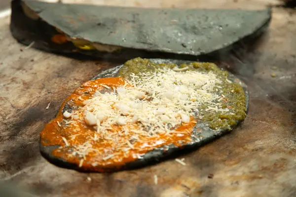 Kabak çiçeği, huitlacoche ve peynirli quesadilla. Meksika, Puebla 'daki Cholula pazarında geleneksel bir komal üzerinde mor mısırla yapılır..
