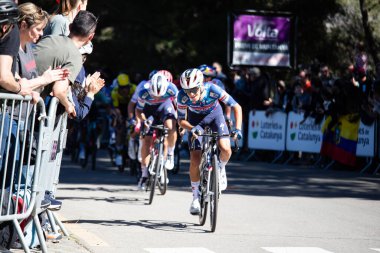 Barselona, İspanya; 1 Nisan 2025: Profesyonel yol bisikletçileri Junior Lecerf Barcelona 'da bir spor müsabakasında yarışıyor. 
