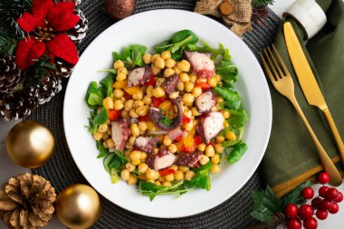 Salpicon de pulpo 'da. Nohut, roka ve sebzeli ahtapot salatası. Noel süslemeleri ile en üstteki görünüm masası.