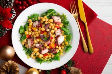 Salpicon de pulpo 'da. Nohut, roka ve sebzeli ahtapot salatası. Noel süslemeleri ile en üstteki görünüm masası.