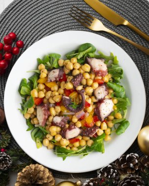Salpicon de pulpo 'da. Nohut, roka ve sebzeli ahtapot salatası. Noel süslemeleri ile en üstteki görünüm masası.