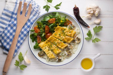 Peynir, pirinç ve salata ile dolu bir omlet ile tabak. Noel süslemeleri ile en üstteki görünüm masası.