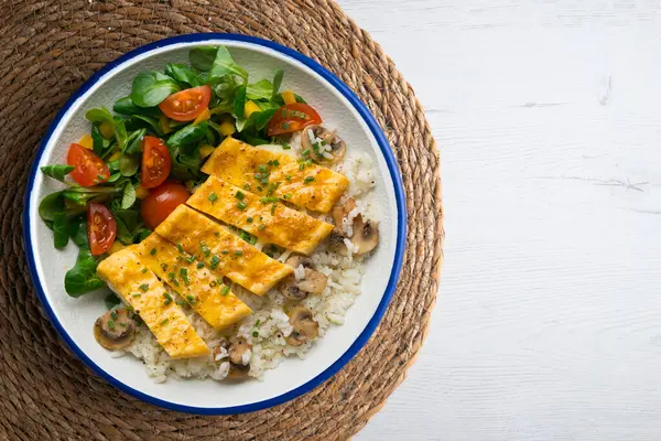 Peynir, pirinç ve salata ile dolu bir omlet ile tabak. Noel süslemeleri ile en üstteki görünüm masası.