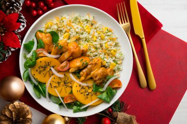 Tavuk, hurma salatası ve pilavla kombinasyon tabağı. Noel süslemeleri ile en üstteki görünüm masası.