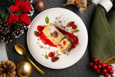 Cevizli, ahududulu, beyaz çikolatalı kek. Noel süslemeleri ile birlikte en üstteki masa..