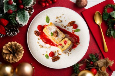 Cevizli, ahududulu, beyaz çikolatalı kek. Noel süslemeleri ile birlikte en üstteki masa..