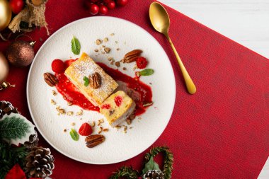 Cevizli, ahududulu, beyaz çikolatalı kek. Noel süslemeleri ile birlikte en üstteki masa..