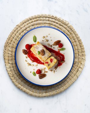 Cevizli, ahududulu, beyaz çikolatalı kek. Noel süslemeleri ile birlikte en üstteki masa..